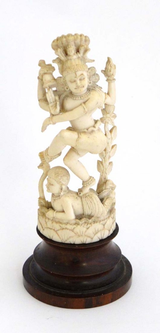 Hindu : a 19thC carved ivory depiction of the God: Hindu : a 19thC carved ivory depiction of the God Vishnu standing on a figure which holds a snake, Vishnu holds conch shell in one hand and rings a bell with the second ( the other two hold nothing),