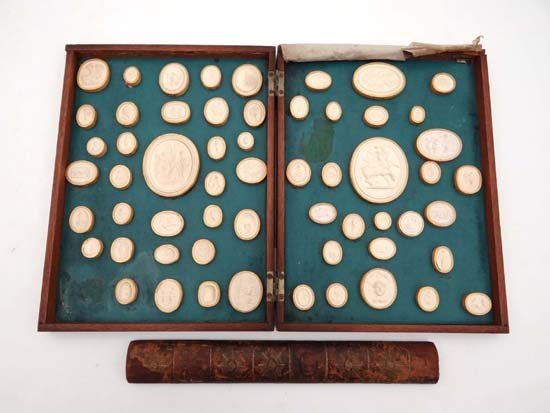 18thC Grand Tour : a superb set of 58 plaster cast: 18thC Grand Tour : a superb set of 58 plaster cast Intaglio seals housed in a Cuban mahogany book form case. The case with a leather spine having remains of gilt tooling and title ' Grecian Gems ' , t