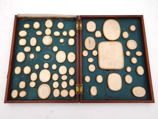18thC Grand Tour : a superb set of 69 plaster cast: 18thC Grand Tour : a superb set of 69 plaster cast Intaglio seals housed in a Cuban mahogany book form case. The case with a leather spine having remains of gilt tooling and title ' Egyptian Gems ' ,