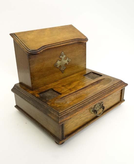 A Neo Gothic oak stationary rack / desk Standish with: A Neo Gothic oak stationary rack / desk Standish with brass Gothic decoration and drawer to base. 10 1/4" wide £40 - 80