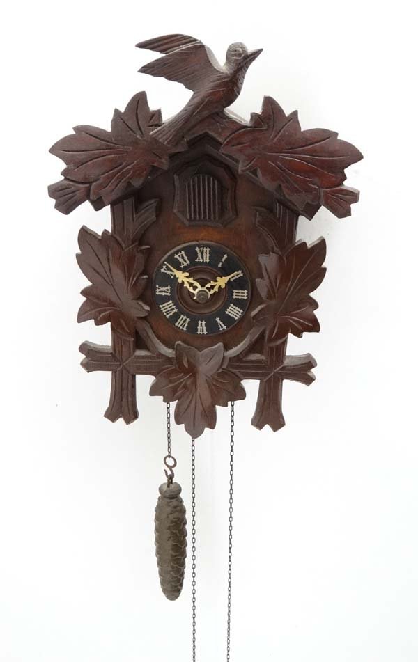 Black Forest Clock : a two weight 20 th C wall Cuckoo: Black Forest Clock : a two weight 20 th C wall Cuckoo clock with two bellows striking on the hour and half hour, the case 12 1/4" high £40 - 60