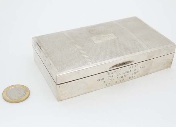 An Art Deco Indian silver table top cigarette box with: An Art Deco Indian silver table top cigarette box with engine turned decoration to the hinged lid opening to reveal a wood lined interior. Engraved ' HAPPY DAYS ' From the officers and men of the Traf