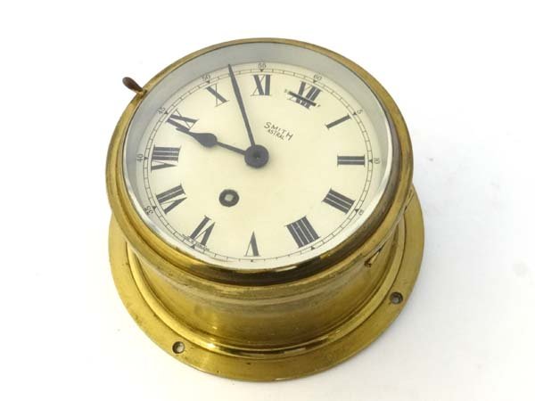 Ship's Clock : a 6" Smith Astral brass cased ship's: Ship's Clock : a 6" Smith Astral brass cased ship's wall timepiece with painted dial showing Roman Numerals and minute markers and single winder between dead centre and 6. With slow -fast at 12 £80 -