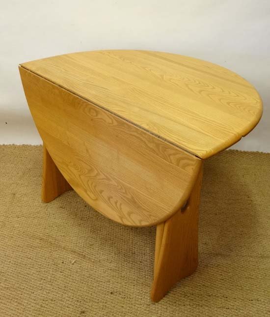 Vintage Retro : Ercol a blonde oak circular drop flap,: Vintage Retro : Ercol a blonde oak circular drop flap, gateleg table with pierced trestle ends,42" diameter Please Note - Prospective purchasers must satisfy themselves as to the condition of lots pri