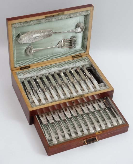 A cased canteen of silver plate and mother of pearl: A cased canteen of silver plate and mother of pearl handled flatware comprising a 12 place set of fish eaters together with a 12 place set of fruit knives and forks ( one knife without handle) togethe