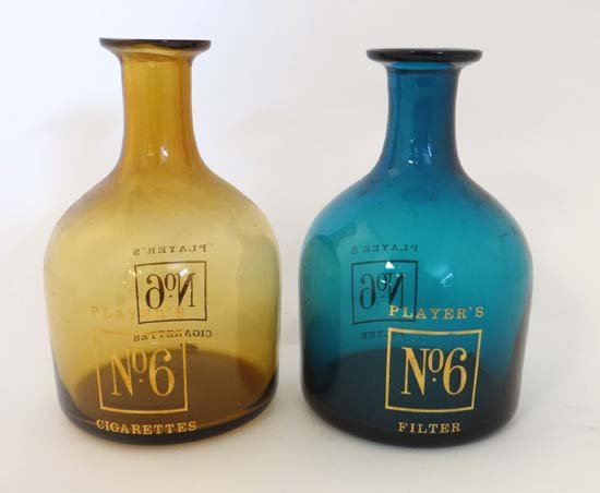 Advertising : Players No 6 Cigarettes - 2 decanters one: Advertising : Players No 6 Cigarettes - 2 decanters one of amber glass, the other blue glass. approx. 7 1/2" high Please Note - Prospective purchasers must satisfy themselves as to the condition of lo
