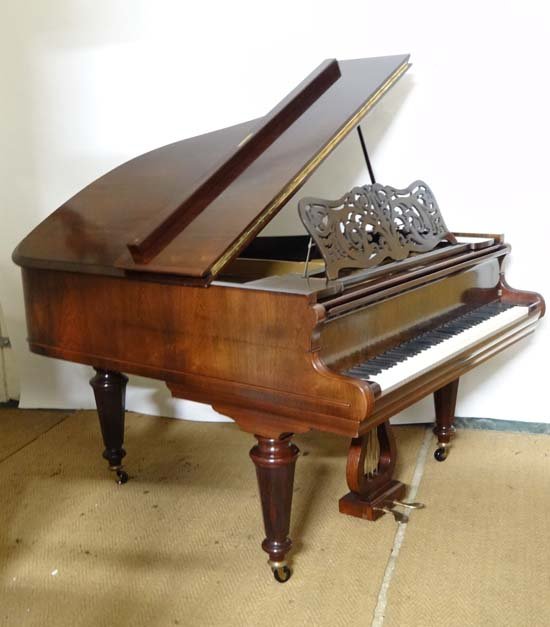 Musical Instruments : A c1915 baby grand piano by: Musical Instruments : A c1915 baby grand piano by Collard & Collard , London . Rosewood construction with named cast iron plate and spruce soundboard , seven octave keyboard , sustain and damper pedal