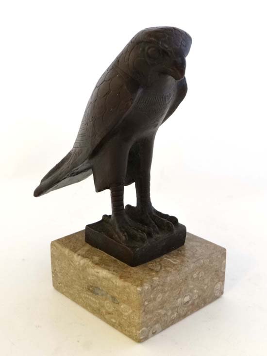 A cast bronze in the Art Deco / Egyptian style: A cast bronze in the Art Deco / Egyptian style depicting a falcon mounted upon a squared marble base 7 1/4" high £30 - 50