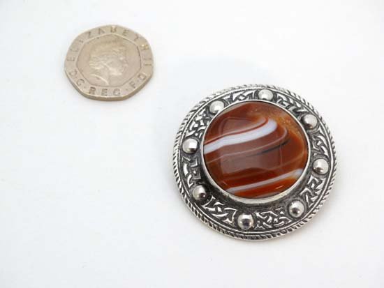 A Scottish HM silver brooch with Celtic decoration and: A Scottish HM silver brooch with Celtic decoration and set with central agate cabachon. Bearing hallmarks for Glasgow 1956 maker Robert Allison 1 1/2" diameter £40 - 60