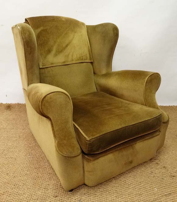 An early - mid 20thC wingback upholstered armchair with: An early - mid 20thC wingback upholstered armchair with scroll out arms and feather squab cushion 34" high Please Note - we do not make reference to the condition of lots within catalogue descriptions
