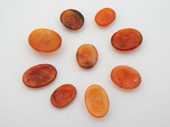 Assorted carved cornelian hardstone intaglio seals. The: Assorted carved cornelian hardstone intaglio seals. The largest 5 1/8" high