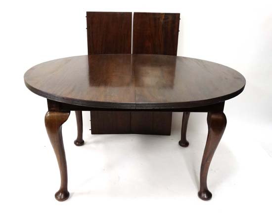 A C.1900 oval extending Queen Anne Style mahogany: A C.1900 oval extending Queen Anne Style mahogany dining table ( wind out ) standing on cabriole legs with pad feet. Extending to approx 83" long x 41" wide Please Note - we do not make reference to t