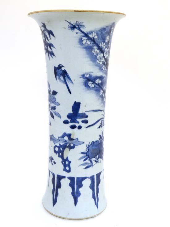 A transitional blue and white gu-form beaker vase China: A transitional blue and white gu-form beaker vase China , c. 1600 Of flared form, the main scene painted with a bird among plum blossom, chrysanthemum and pine trees, above a band of flowers and rocks