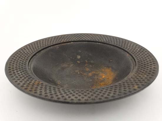 An Asian cast iron signed dish with dimpled border: An Asian cast iron signed dish with dimpled border decoration and 2 character marks under. 6 3/4" 6 13/16" diameter Please Note - we do not make reference to the condition of lots within catalogue des