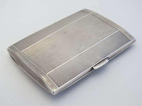 An Art Deco silver cigarette case with engine turned: An Art Deco silver cigarette case with engine turned decoration and gilded interior. Hallmarked Birmingham 1930 maker Henry Matthews. 3 1/4" x 1 1/4" (70g) Please Note - we do not make reference to th