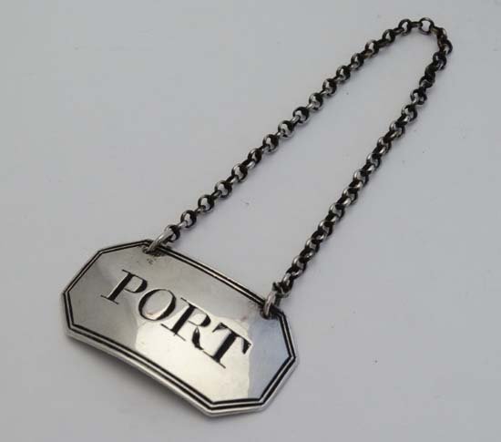 A Geo III silver decanter / wine label ' PORT' with: A Geo III silver decanter / wine label ' PORT' with reeded border and canted corners. Hallmarked London 1799 maker EM (8g)