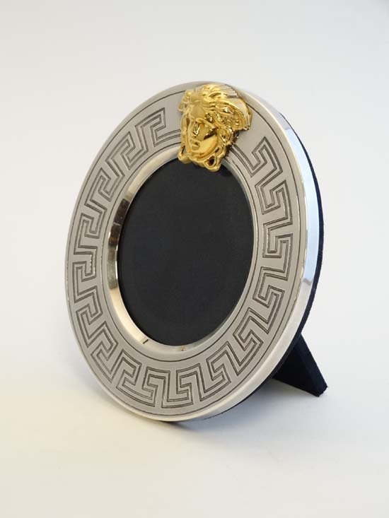 An Italian silver photograph frame of circular form: An Italian silver photograph frame of circular form marked ' Gianni Versace ' 6" high £150 - 180