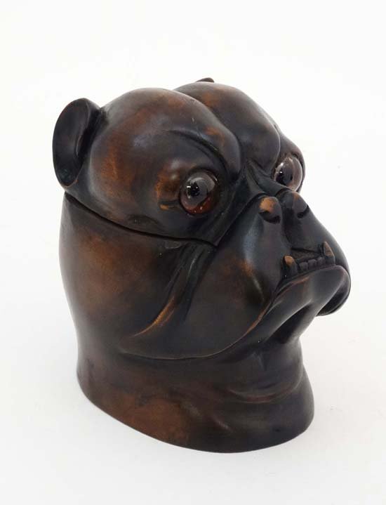 A 20thC Black Forest tobacco jar in the form of a boxer: A 20thC Black Forest tobacco jar in the form of a boxer dog head with glass eyes. 6" high £200 - 250