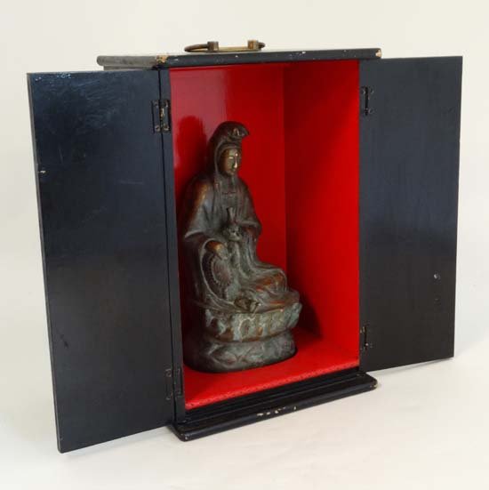 A 19th C hollow bronze sculpture of the Bodhisattva: A 19th C hollow bronze sculpture of the Bodhisattva Goddess Quan Yin (Goddess of Compassion and Mercy) seated upon a lotus flower and holding a vase and necklace. Contained within a painted black exte