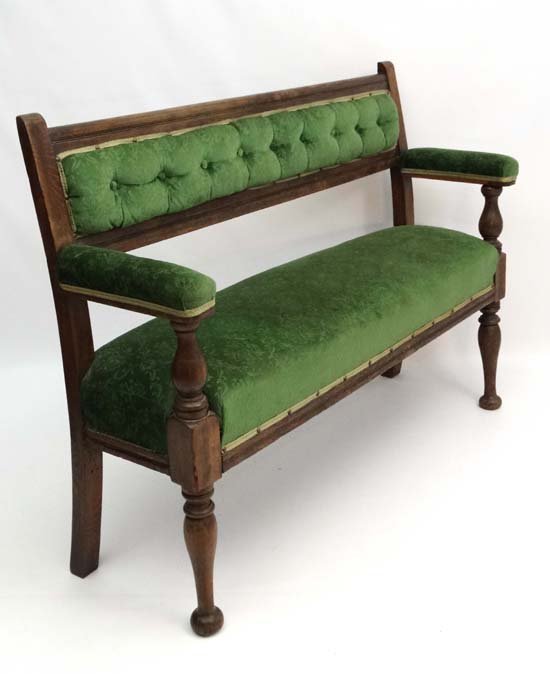 A Victorian oak Railway? bench with baluster turned arm: A Victorian oak Railway? bench with baluster turned arm supports button back armrests upholstered seat and arms. 39'' high x 54'' wide x 16'' deep