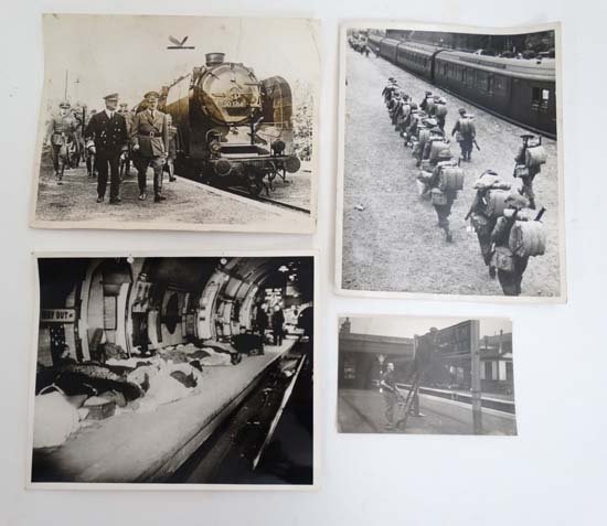 Militaria : A selection of four WWII press photographs: Militaria : A selection of four WWII press photographs of various subjects , comprising Adolf Hitler with Admiral Hortly beside an armored train on the Russian Front , two workmen ' blacking-out ' a s