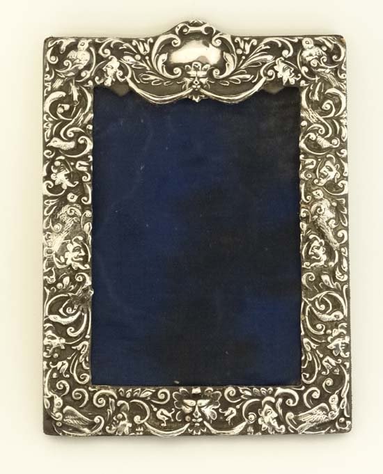 A silver mounted photograph frame with embossed: A silver mounted photograph frame with embossed decoration. Hallmarked Birmingham 1903 maker Henry Matthews. The whole 7 1/4'' high