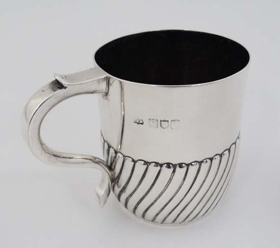 A Victorian silver Christening mug with half fluted: A Victorian silver Christening mug with half fluted decoration Hallmarked London 1896 maker Mappin & Webb ( John Newton Mappin) and stamped under Mappin & Webb London 3'' high (138g)