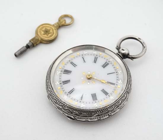 A 19 thC Continental .935 Silver ( marked ) Fob watch ,: A 19 thC Continental .935 Silver ( marked ) Fob watch , having profusely carved case, key wind movement , the dial with gilt and silvered inlay , minut markers and Roman Numerals with gilt hands. 1 3/