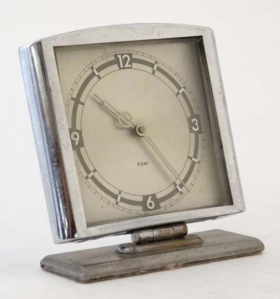 Art Deco clock ( timepiece ) : a Chromium cased 8 day: Art Deco clock ( timepiece ) : a Chromium cased 8 day timepiece with fast- slow marker , integral winder and mounted on a steel base, 4 1/2'' wide x 41/2'' high
