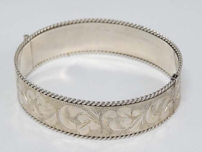 A silver bangle with engraved floral scroll and rope (1 of 4)