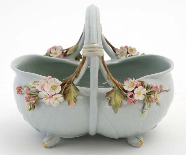 A c1891 Mintons majolica floral basket , shape number: A c1891 Mintons majolica floral basket , shape number 1603, the body of pale blue having applied blossom detail to base of handle, sitting on four feet, bears impressed factory marks to base. 5 1/4'' 