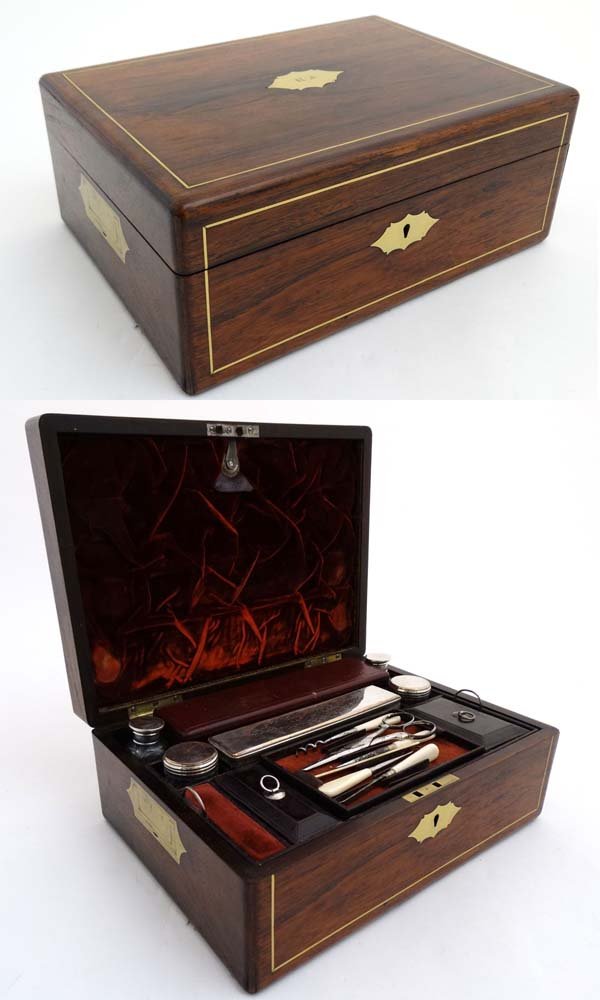 A brass inlaid rosewood work box opening to reveal: A brass inlaid rosewood work box opening to reveal leather lined interior, Old Sheffield Plate toped bottles, with an assorted writing instruments, inkwell, double ended protracting pen and pencil etc