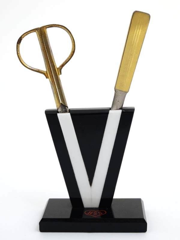 An Art Deco desk top plastic holder / tidy for scissors: An Art Deco desk top plastic holder / tidy for scissors and paper knife. The whole standing 6 3/4'' high