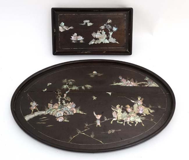 A Chinese native hardwood oval tray depicting abalone: A Chinese native hardwood oval tray depicting abalone and mother of pearl inlay together with a smaller oblong tray. the larger 22'' wide x 14 1/3'' (2)
