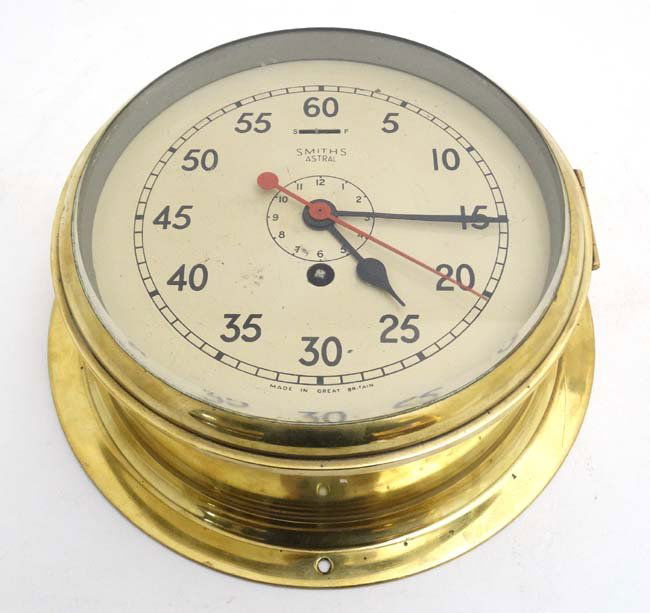 Ship's Brass Clock : a Smiths Astral Timepiece with: Ship's Brass Clock : a Smiths Astral Timepiece with central red sweeping seconds hand, seconds dial and black hours hands etc. With inner black dial, 8'' bevelled glass fronted dial.