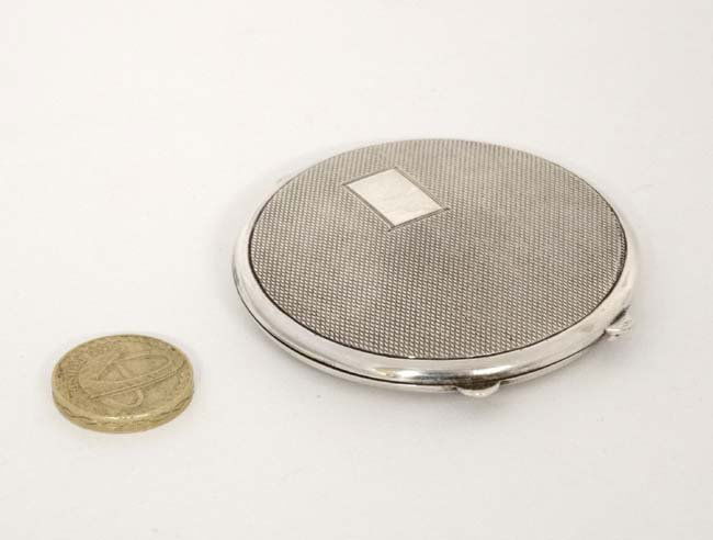 A silver powder compact with engine turned decoration. (1 of 6)