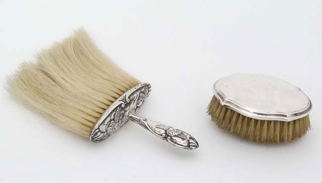 A silver backed brush hallmarked Birmingham 1927 maker: A silver backed brush hallmarked Birmingham 1927 maker Levi & Salaman, together with a hat brush with embossed cherub decoration to handle hallmarked Birmingham 1906 maker William Harrison Walter