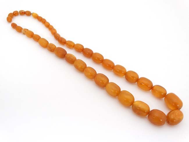 A string of graduated amber coloured beads approx. 24'' (1 of 3)