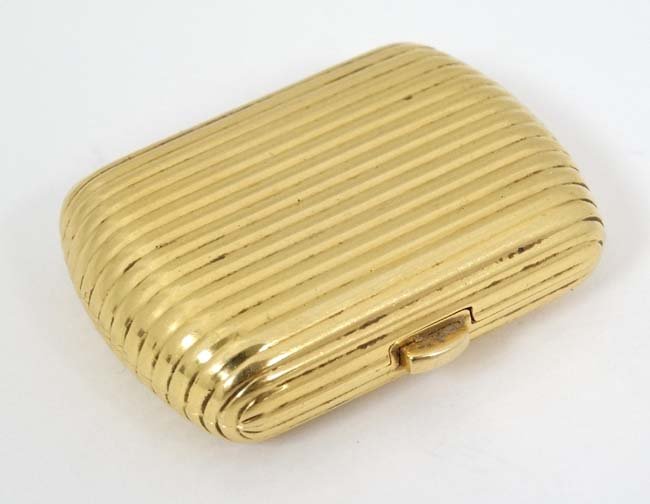 .18 KT Fred Paris box : a .750 sprung hinge reeded box: .18 KT Fred Paris box : a .750 sprung hinge reeded box , signed , of reeded cartouche shape , 1. 75'' long x 1 1/5'' deep x 1/2'' high , 43 gms