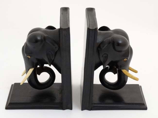 A pair of 1930's ebony bookends with elephant head: A pair of 1930's ebony bookends with elephant head decoration. Approx 5'' long x 7'' high