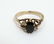 A gold ring set with dark semi-precious stone flaked by