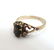 A gold ring set with dark semi-precious stone flaked by - 2