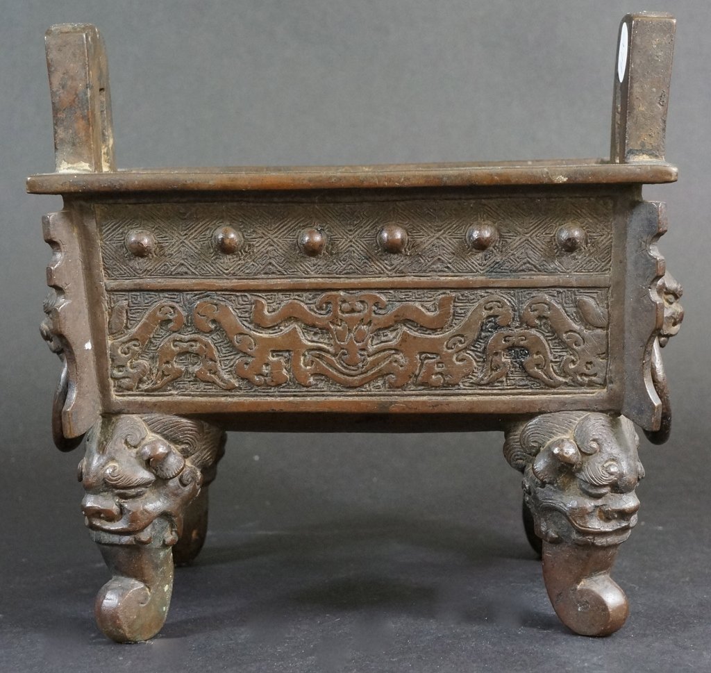 Chinese 18th Century Bronze Ding Shaped Censer: Of rectangular form and foolion mask with loose rings on each sides. Measures 8" in wide and 7.5" in height.