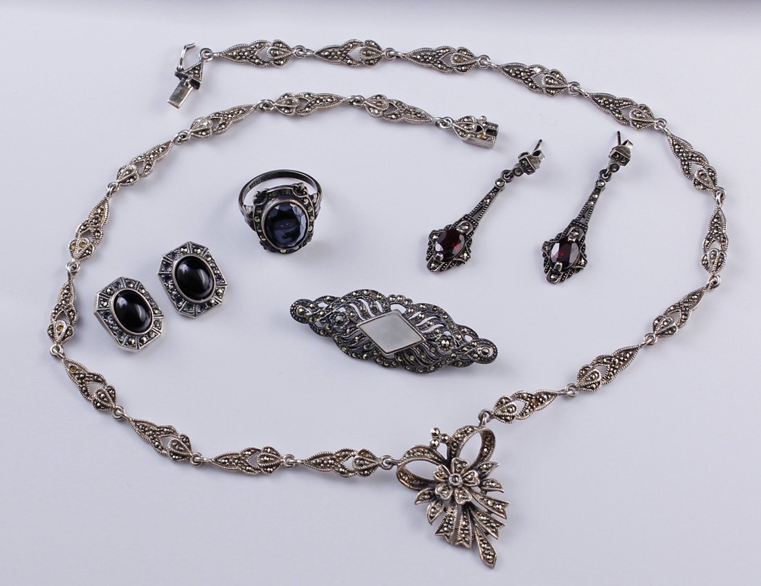 Lot of Marcasite Onyx Sterling Silver Jewelry: Lot of Marcasite Onyx Sterling Silver Jewelry including Mother of Pearl, Garnet and onyx accents Sizes - 2" length brooch 1/2" x 3/4" earrings (clip) 1 1/2" length earrings (pierced) 19 1/2" length ne