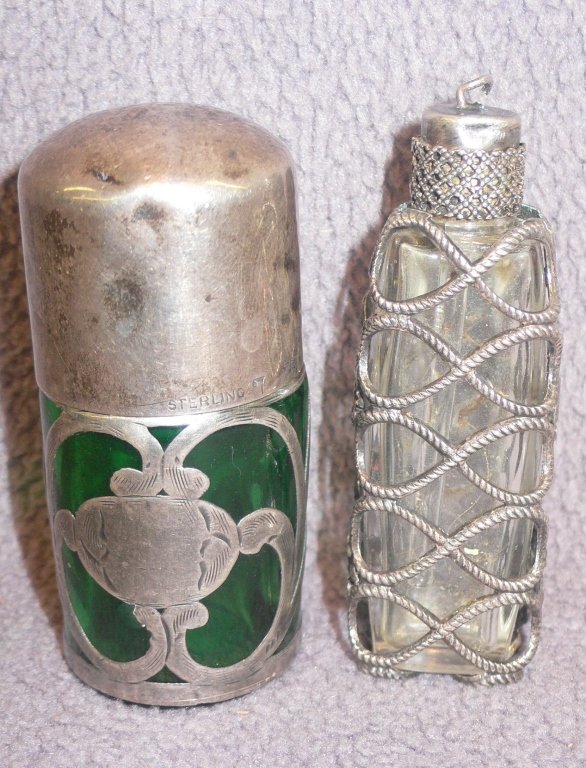 Two antique silver and glass perfume bottles: Two antique silver and glass perfume bottles with fine worked sterling silver overlay. 19th C., one in deep green, the other clear