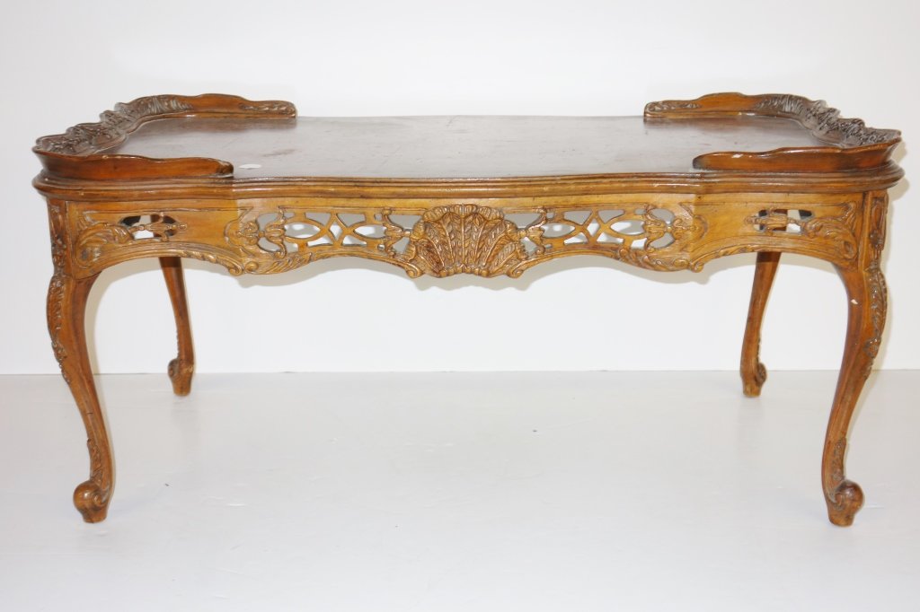 Ornate carved wood coffee table: Ornate carved wood coffee table. Crack. 38 inches x 20 1/2 inches x 18 inches.