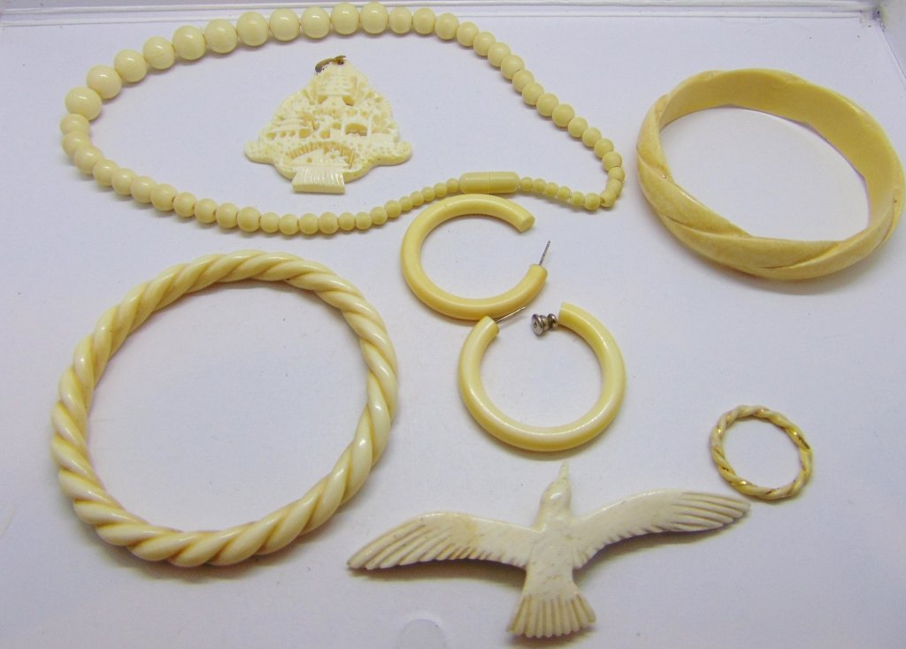 antique carved bone jewelry lot: antique carved bone jewelry lot consisting of 2 bangle style bracelets carved bird ornament (missing pin back), deeply carved Pagoda pendant, Beads & twist ring, hoop earrings.