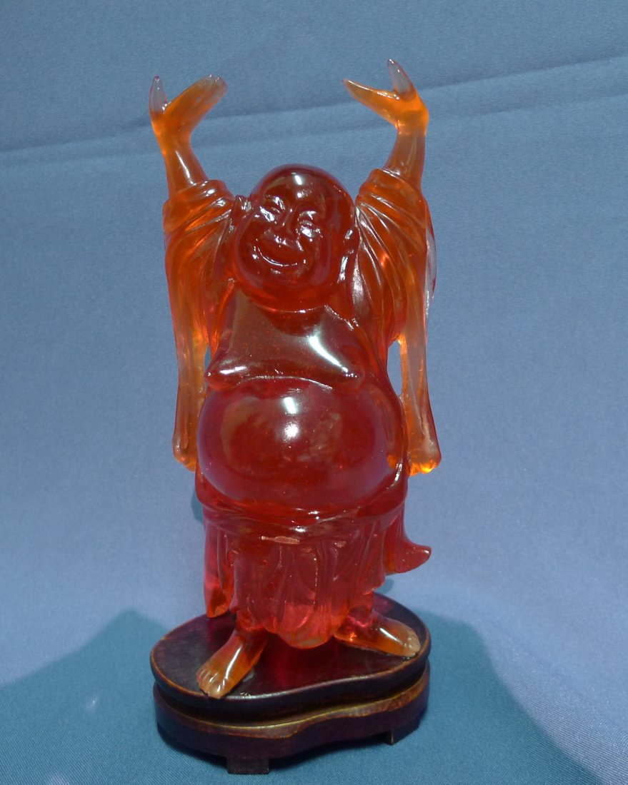A Chinese Antique Amber Stanting Of Buddha: A Chinese Amber standing Buddha: A Chinese Antique Amber Statue of Buddha,carved from the Amber with warm red brown tone as a laughing Buddha seated on while both arms up, Minguo Period; Size: H: 23cm