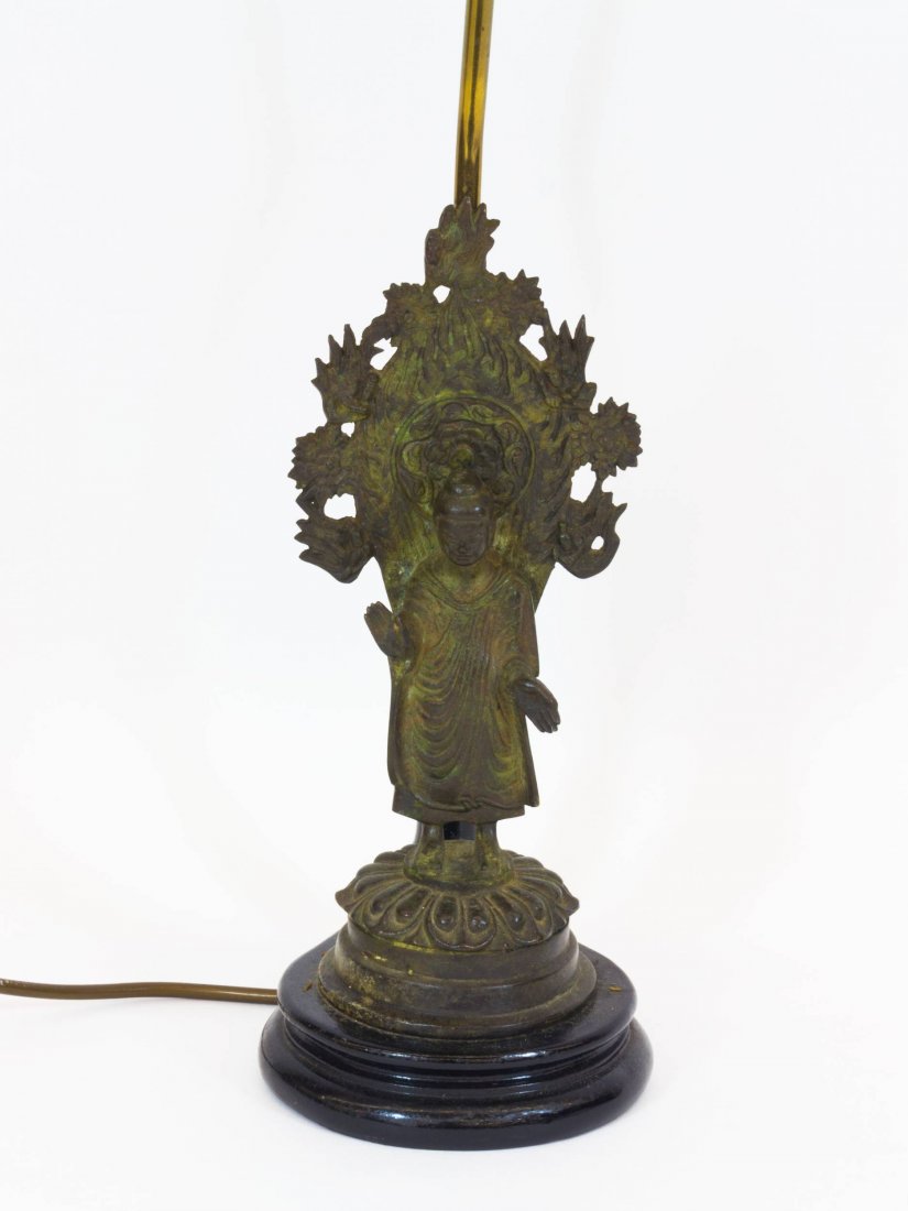 Ausgefallener Lampenfuß: auf rundem, profiliertem: Eccentric lamp base: mounted on round, profiled and ebonised stand bronze figure of a Buddhist deity, two lamps, bronze figure H 30.5 cm, height 58 cm
