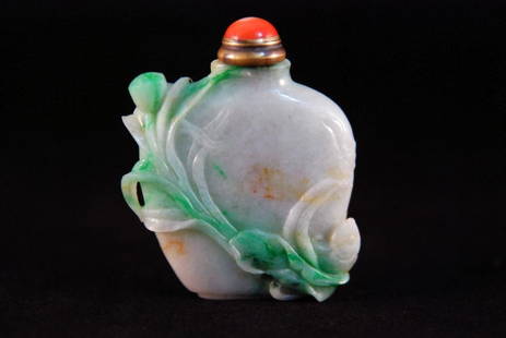 A WHITE AND GREEN JADE SNUFF BOTTLES: Of flattened baluster shape form with a narrow flat rim to the cylindrical neck, raised relief with fruiting and flowering vines and veined leaves. Height: 2 3/8in (6cm).